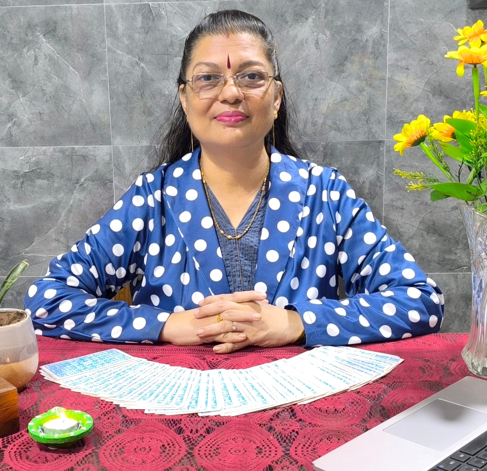 Rekha Rawatt at her reading table with a fanned tarot deck